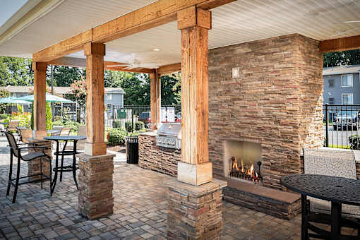 A patio with a fireplace and chairs.