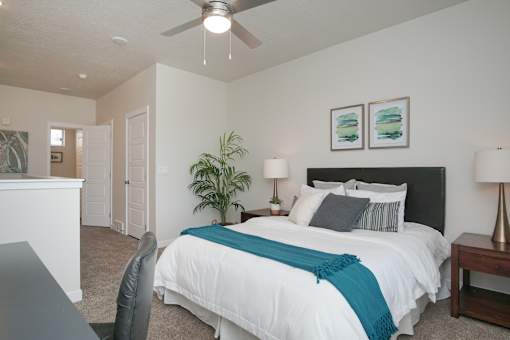 Spacious bedroom with ceiling fan and artwork at Liberty Point Apartments, Utah, 84020