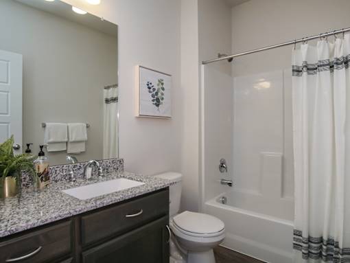Modern bathroom with granite vanity and tub at Liberty Point Apartments, Draper, UT 84020