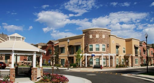 Liberty Landing Front Entrance with Gazebo, white wooden pergola and tan buildings.