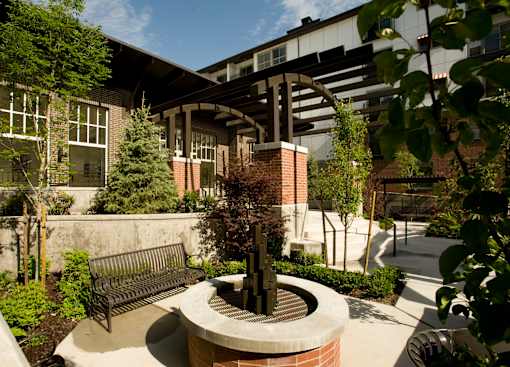 Liberty Gateway Apartments, Salt Lake City, Utah, a courtyard with a fountain and bench in front of a building.