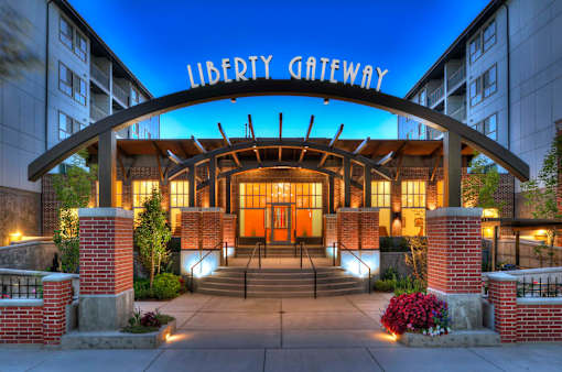 Liberty Gateway Apartments, Salt Lake City, UT, The entrance to the Liberty Gateway building is shown at dusk.