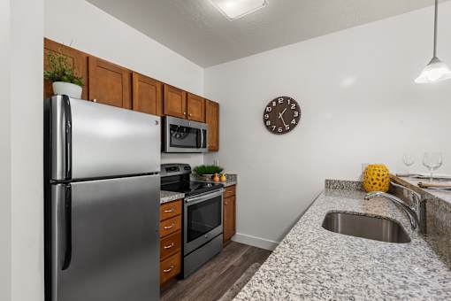 Compact kitchen with stainless steel appliances and granite countertops at Liberty Gateway Apartments, Salt Lake City, UT 84101