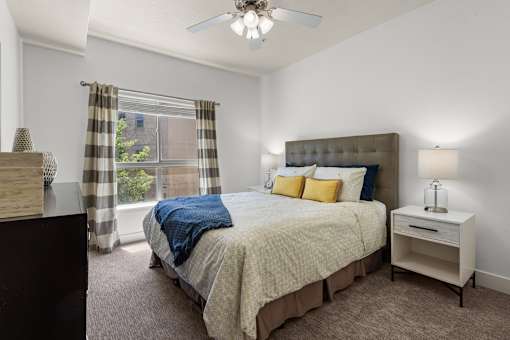 Bedroom with upholstered headboard and natural light at Liberty Gateway Apartments, Salt Lake City, Utah