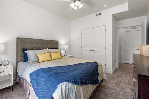 Bedroom with tufted headboard and closet doors at Liberty Gateway Apartments, Salt Lake City