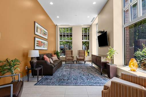 Community lounge with television and upholstered chairs at Liberty Gateway Apartments, Utah, 84101