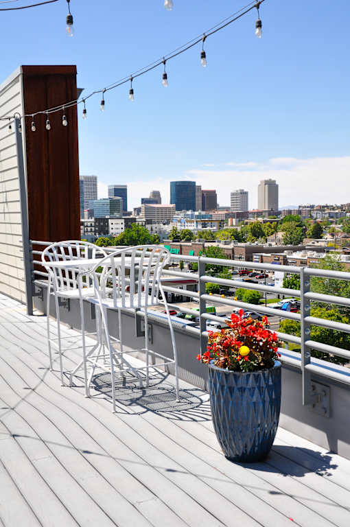 A patio with a table and chairs overlooking a city skyline.