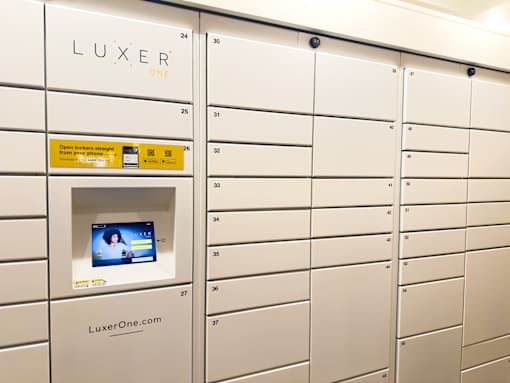 A row of mailboxes with the word LUXER ONE on the wall above them.
