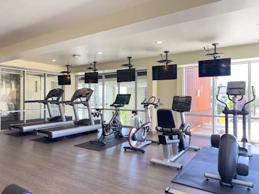 A gym with treadmills, exercise bikes, and weight machines.