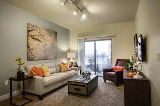 A living room with a couch, a chair, a coffee table, and a painting on the wall.