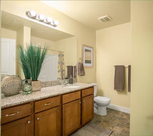 Liberty Gateway Apartments, Salt Lake City, Utah, A bathroom with a toilet, sink, and mirror.