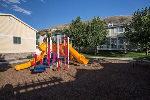 Colorful playground equipment with slides and climbing structure at Liberty Hill Apartments, Draper, 84020