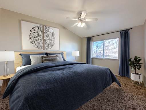 Spacious bedroom with navy linens and modern furnishings at Liberty Hill Apartments, Draper, UT