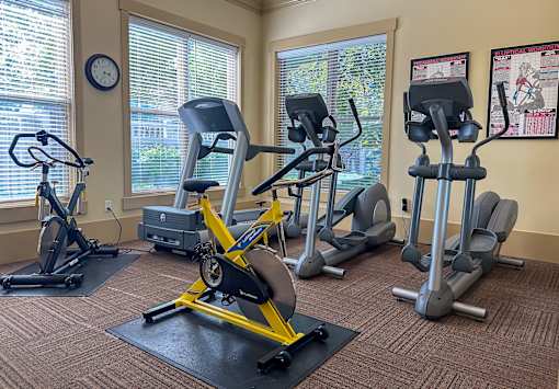 Liberty Landing Apartments, West Jordan, UT, A gym with a variety of equipment including treadmills, stationary bikes, and elliptical machines.