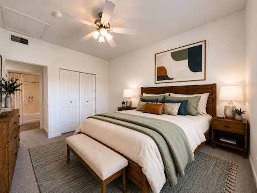 Liberty Landing Apartments, West Jordan, UT, bedroom with a bed, bench, and a ceiling fan.