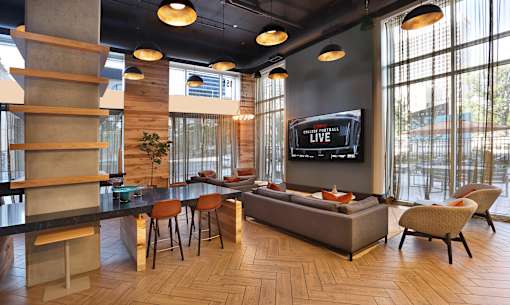 A modern living room with a large TV and comfortable seating.