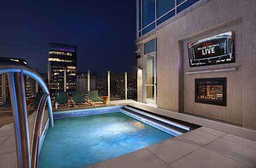 A pool with a slide and a TV on the wall.