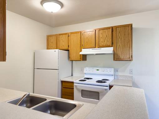 A kitchen with a white refrigerator, white stove, and white oven.