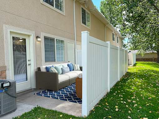 The Ridge at Jordan Landing Apartments, West Jordan, Utah, a patio with an outdoor couch in front of an apartment/townhome.