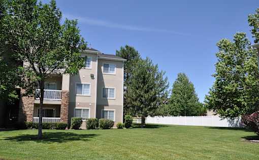 A large grassy area in front of a two-story apartment building.