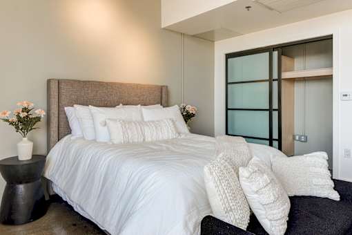 Cozy bed in Maxfield loft bedroom area with aesthetic and functional closet storage