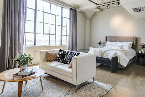 Spacious open concept loft at Maxfield with high wall-to-wall windows, cozy bedroom space, and room for a living area