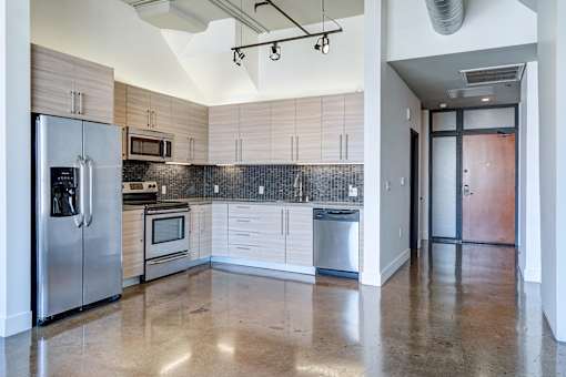 Updated kitchen in Maxfield lofts with modern cabinetry, gorgeous fixtures, updated appliances and a double door fridge.