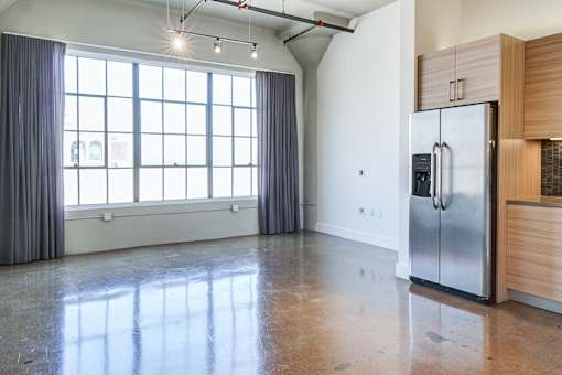 Open concept loft at Maxfield with large wall-to-wall windows overlooking the Downtown los angeles skyline, modern flooring and unique and beautiful aesthetic