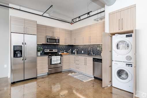 A kitchen with a refrigerator, oven, and microwave.