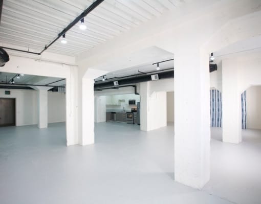 a large white room with white pillars and a white floor at Binford Lofts Apartments, California, 90013