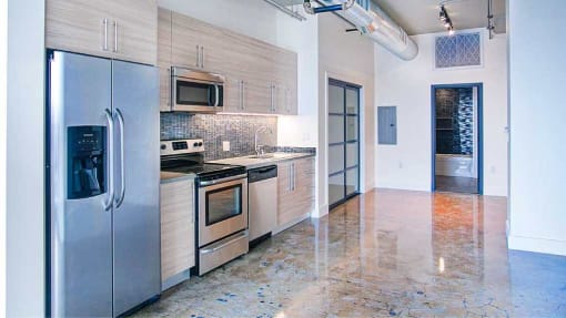a kitchen with stainless steel appliances and a refrigerator at Maxfield Lofts, Los Angeles California