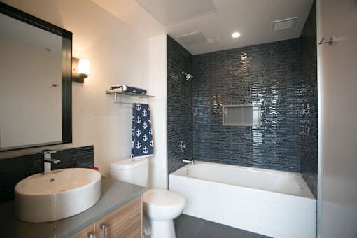 A modern bathroom with a white toilet and a white bathtub.