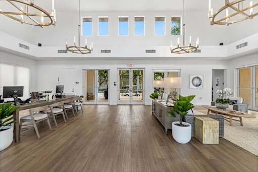 the living room has a large open floorplan with wood floors and white walls