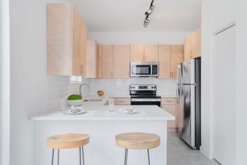 kitchen with wooden cabinets and a counter top with three stools