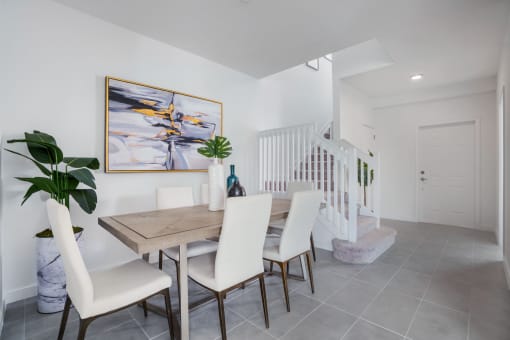 a dining room with a wooden table and white chairs