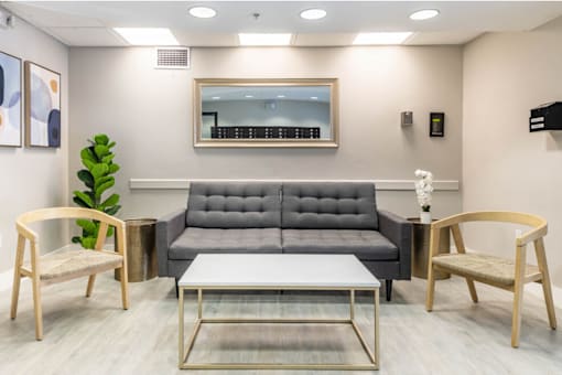 a living room with a gray couch and two chairs at Lakeside @ Biscayne Gardens,North Miami, Florida