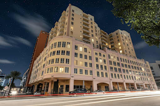 A large, modern building with many windows is illuminated at night.