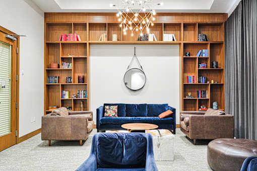 A living room with a blue couch and a chandelier.