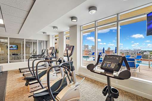A gym with treadmills and a view of the city.