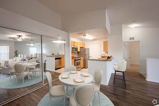 a dining room and kitchen with a table and chairs