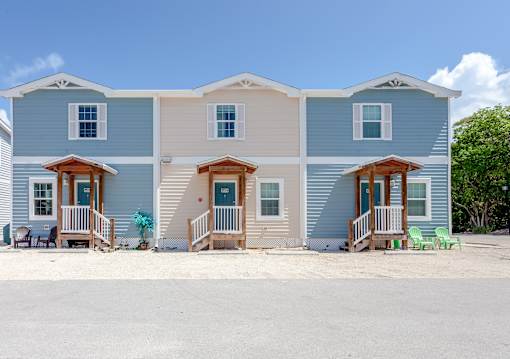 A row of three houses with blue siding and white trim.