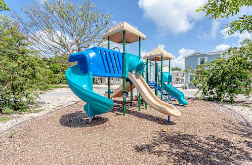 A playground with a blue slide and a yellow top.