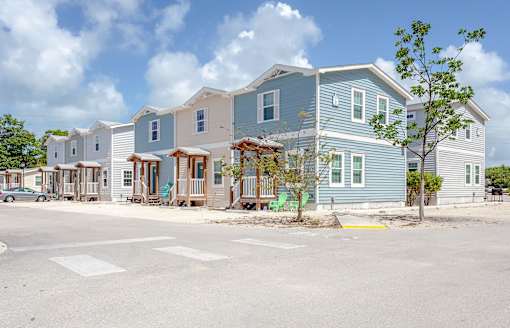 A row of houses with a tree in front of the first house.