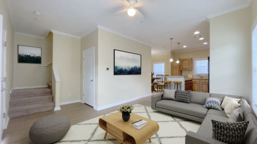 A living room with a grey couch, a coffee table, and a painting on the wall.