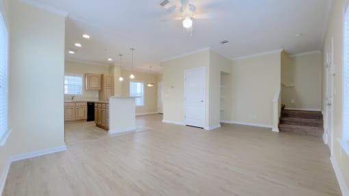 A spacious living room with a staircase leading to the upper floor.