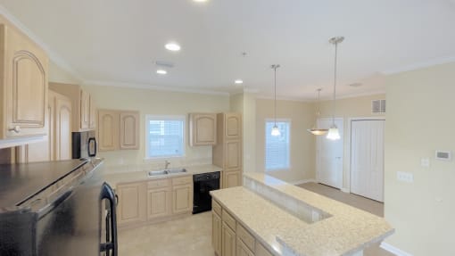 A kitchen with a black refrigerator and a black countertop.