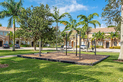 a park with palm trees in front of a building