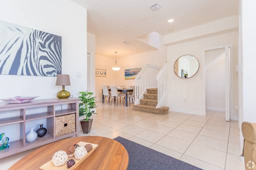 the living room and dining area of a house with a table and chairs