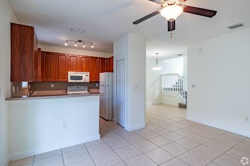 A kitchen with brown cabinets and a white counter.