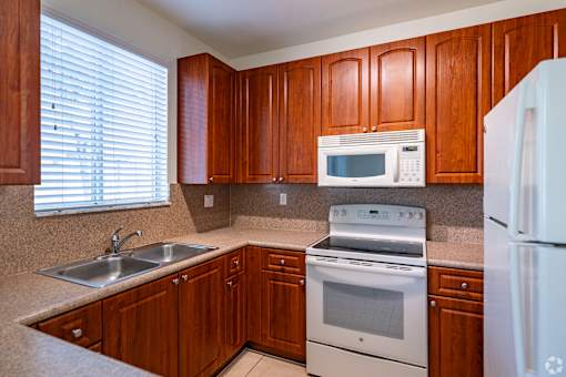 A kitchen with wooden cabinets and white appliances.